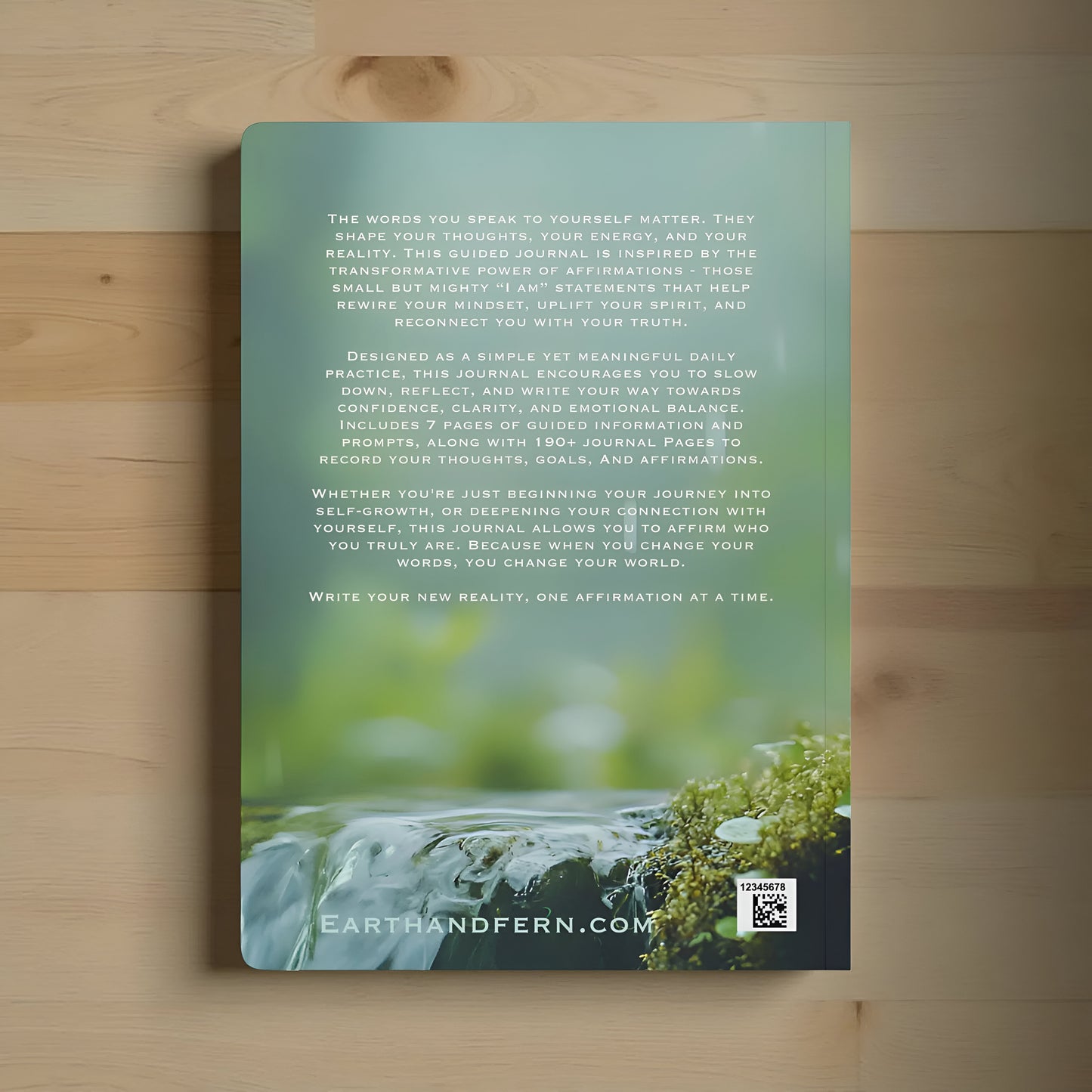 Journal cover with nature-themed flowing water design and text on the back. Journal on a wooden surface