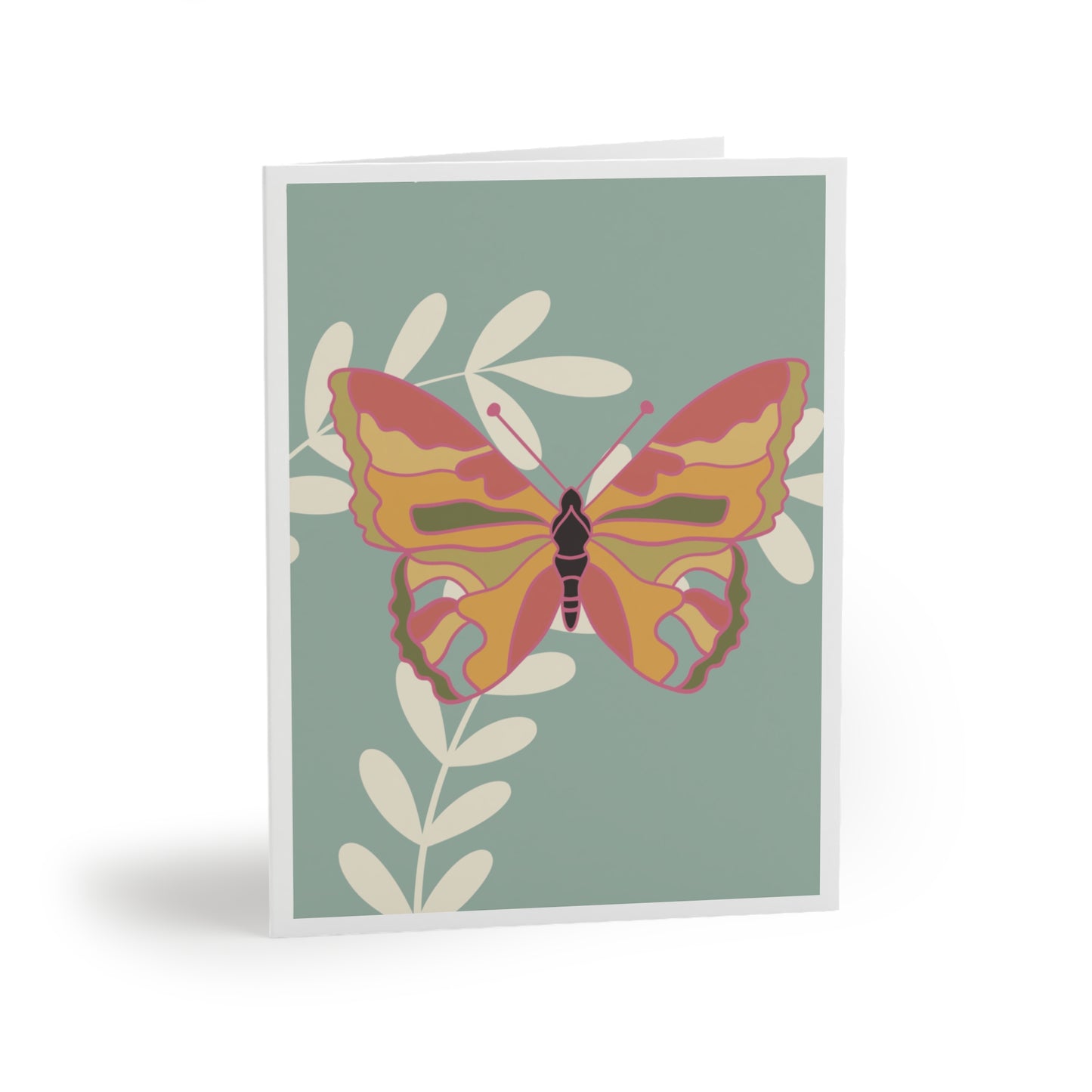 Greeting card - Image shows a yellow, orange, and pink butterfly sitting on cream leaves on a light blue background with white border.