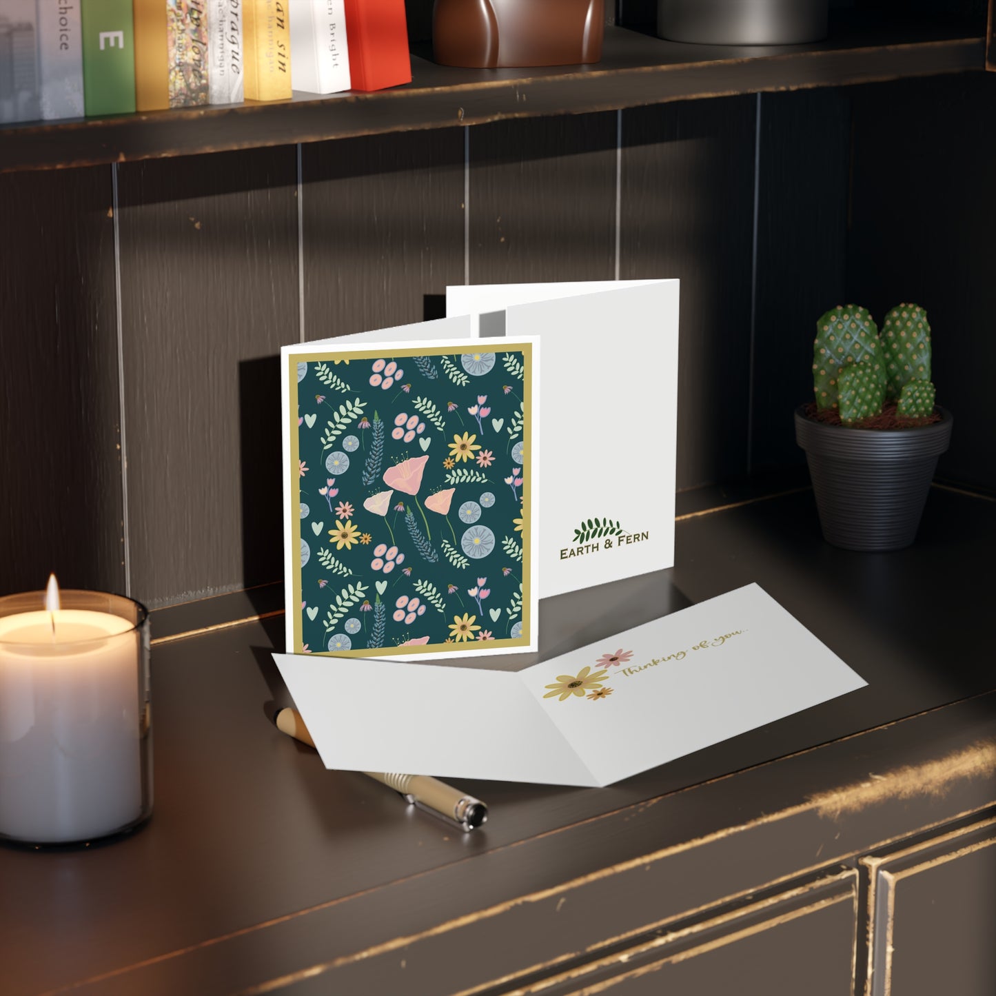 Front of a teal-colored greeting card featuring a soft, pastel floral design with mixed flowers in gentle hues. The card’s elegant teal background complements the pastel flowers, making it perfect for a range of occasions. The inside of the card is blank, ideal for personal messages, with the back displaying the text 'Blank inside' and the company logo