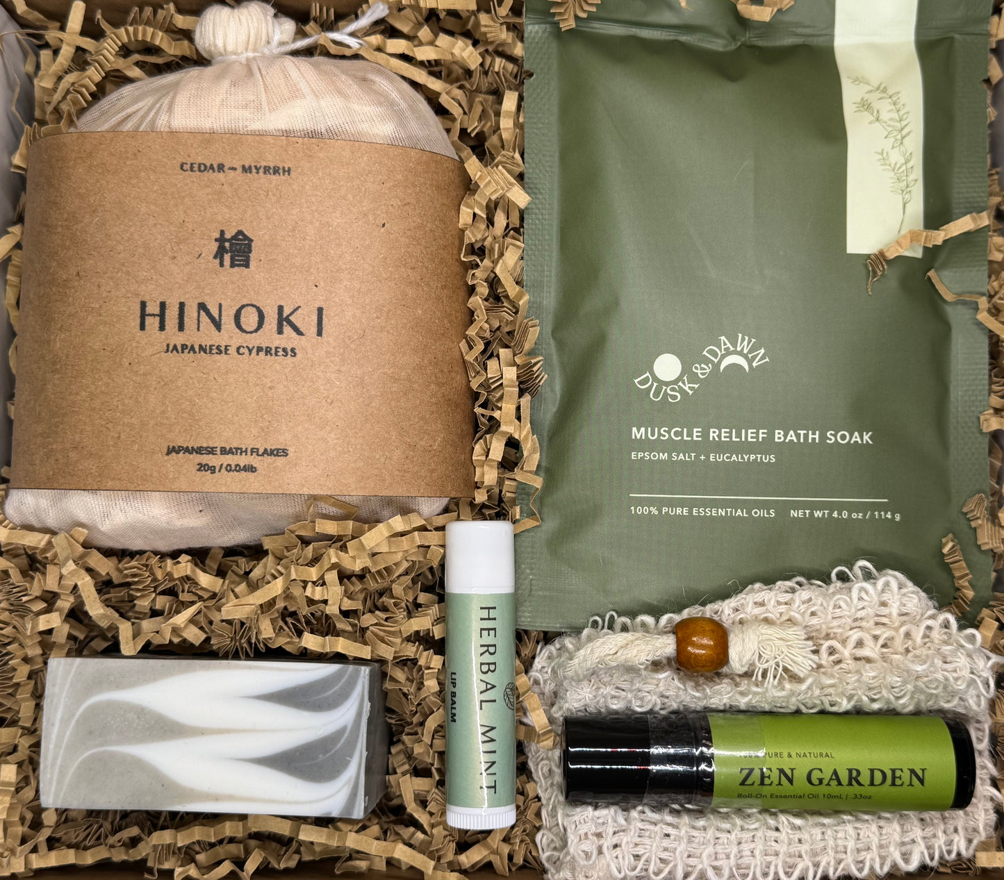 Woodland Ritual wellness box with Hinoki Cypress bath flakes, muscle relief soak, cedarwood pine soap, herbal mint lip balm, and aromatherapy roll-on in a forest-inspired gift set.