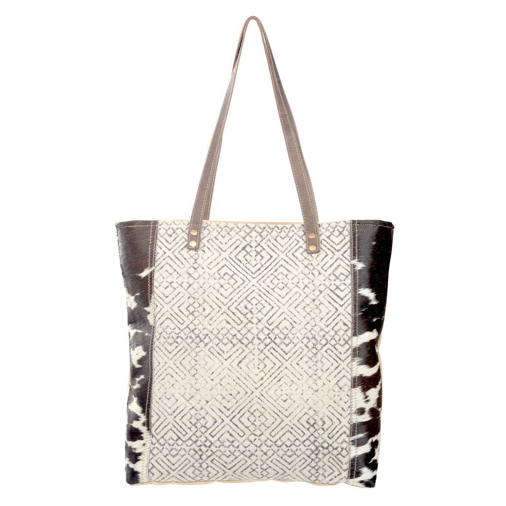 Black and cream geometric design tote with  brown suede leather straps and cowhide accents. Stylish and eco-friendly, perfect for everyday use or as a statement accessory