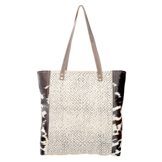 Black and cream geometric design tote with  brown suede leather straps and cowhide accents. Stylish and eco-friendly, perfect for everyday use or as a statement accessory