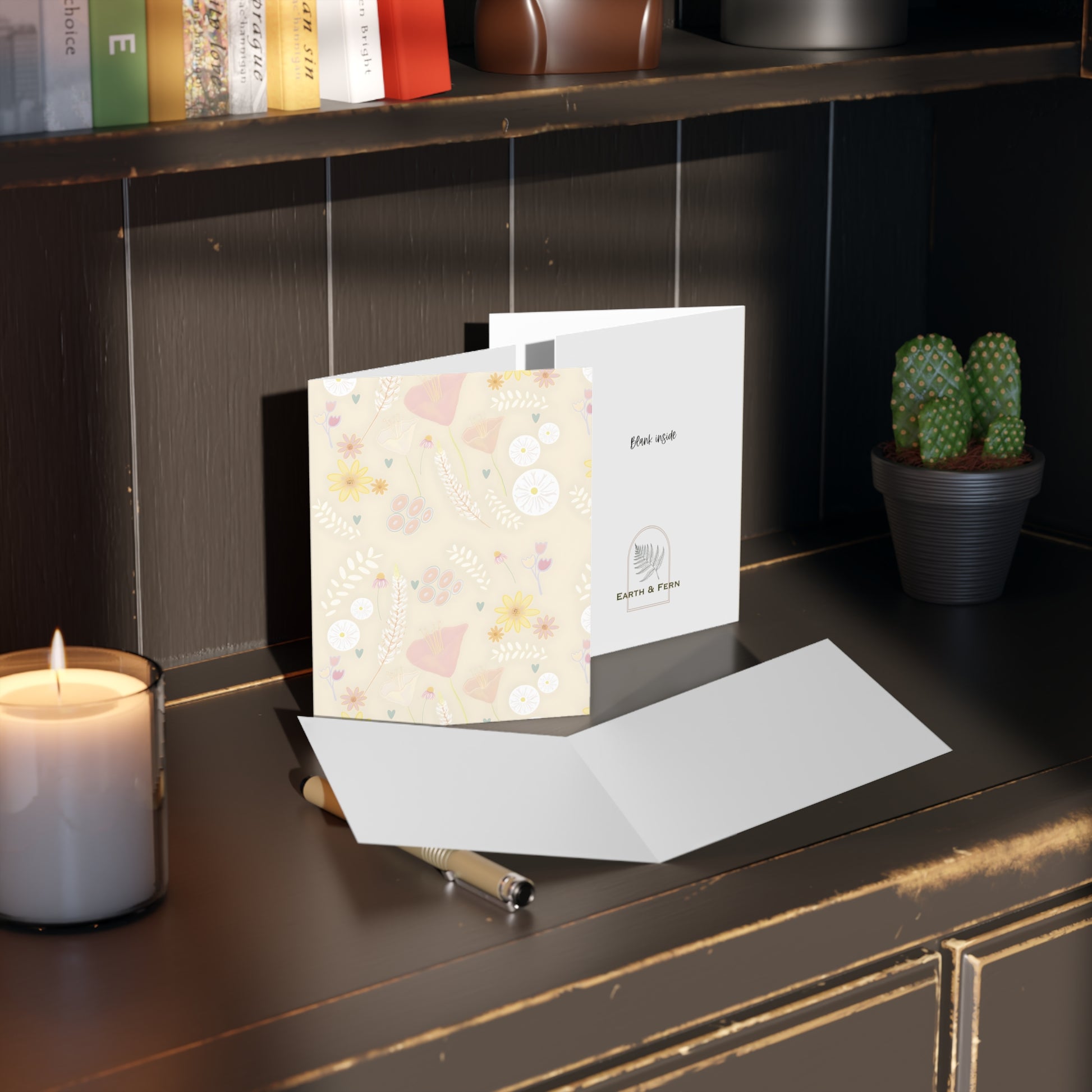 Front of a subtle cream-colored greeting card featuring a soft, pastel floral design with mixed flowers in gentle hues. The card’s minimalist elegance makes it suitable for various occasions. The inside of the card is blank, perfect for adding a personal message, with the back displaying the text 'Blank inside' and the company logo