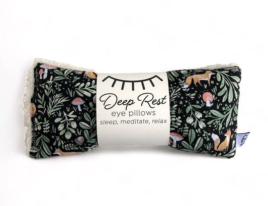 Black with green woodsy leaves with little foxes and mushrooms. Deep Rest Eye Pillow with rice filling for relaxation, stress relief, and improved sleep, featuring a cotton front and soft minky backing, ideal for heating or cooling