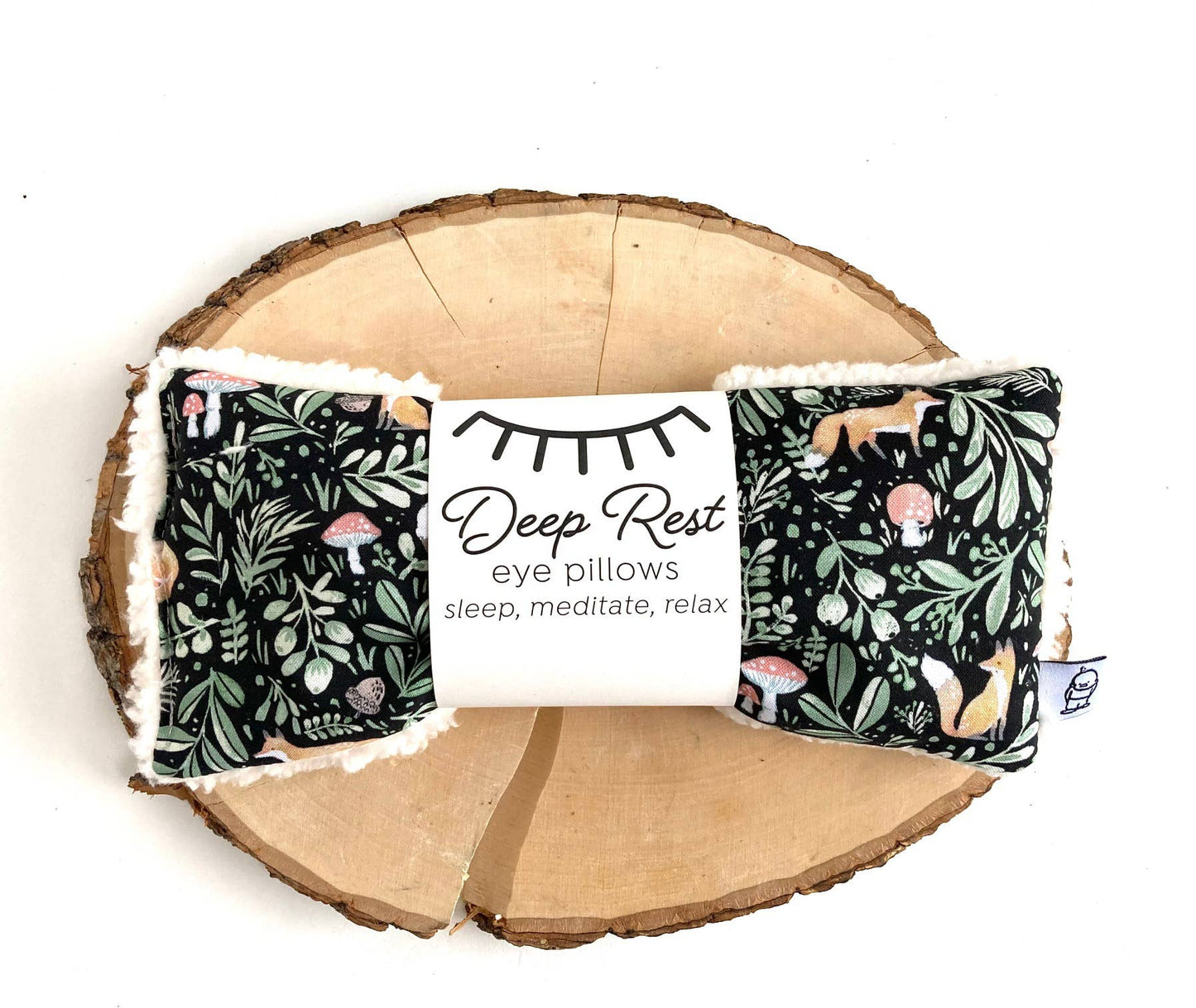 Black with green woodsy leaves with little foxes and mushrooms. Deep Rest Eye Pillow with rice filling for relaxation, stress relief, and improved sleep, featuring a cotton front and soft minky backing, ideal for heating or cooling