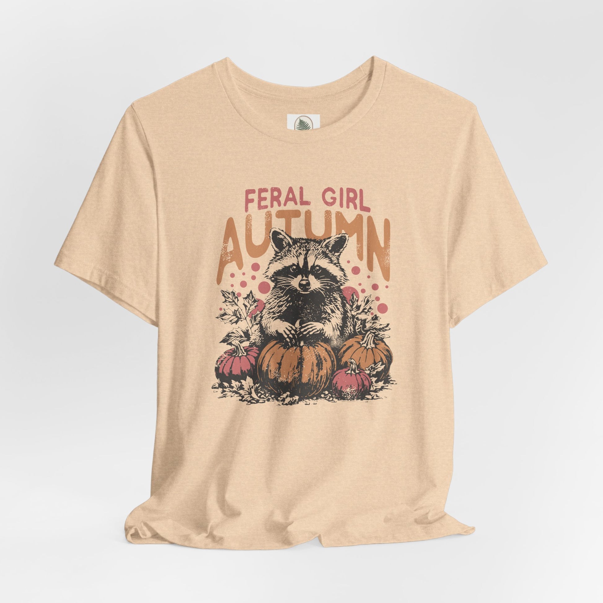 Feral Girl Autumn vintage-style unisex t-shirt featuring a raccoon with pumpkins, retro fall graphic, lightweight and comfortable cotton tee, perfect for pumpkin patch trips and cozy autumn outings, ethically made.