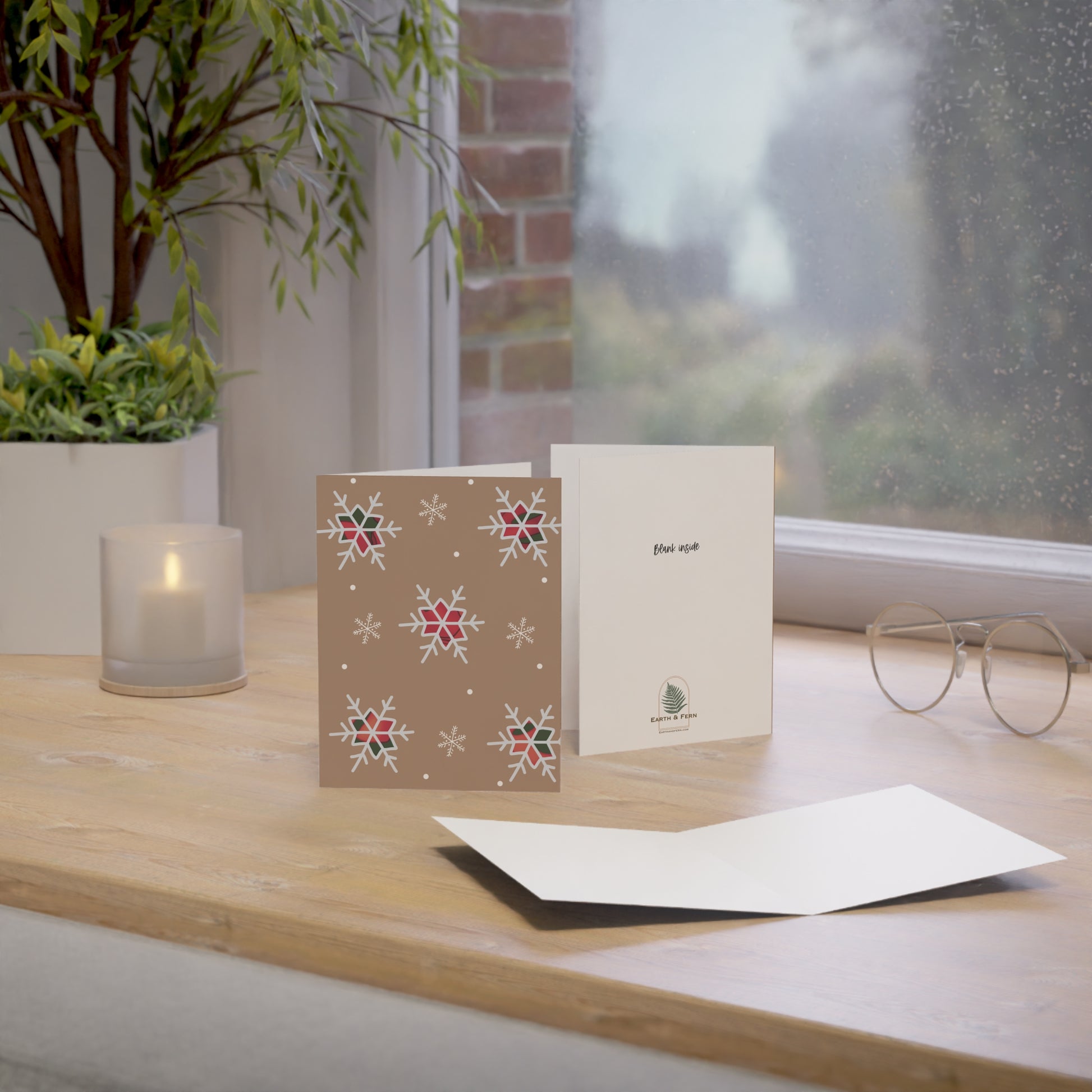 A festive brown kraft card adorned with vibrant red and green plaid snowflakes, creating a warm holiday atmosphere. Blank Inside and Earth and Logo on the back , along with words lank inside