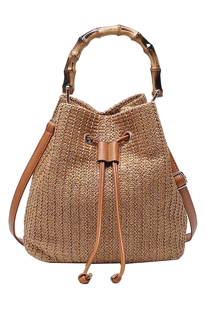 Boho-style woven rattan bucket bag with bamboo top handle and crossbody strap, featuring drawstring closure and inner compartments