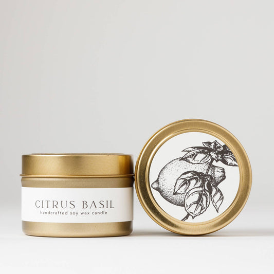 Hand-poured 4 oz. soy candle from the Flora Collection with citrus and herb scents of sweet basil, Meyer lemon, lime, and wild mint, in a gold steel travel tin.