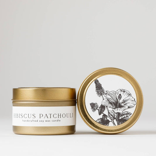 Hand-poured 4 oz. soy candle from the Flora Collection with floral island top notes and patchouli, in a gold steel travel tin.